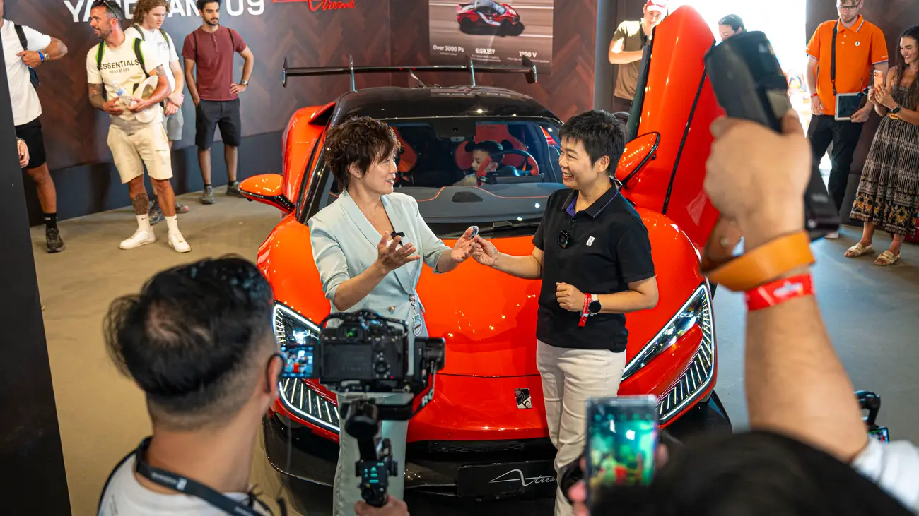 Представители BYD беседуют перед суперкаром Yangwang U9 на Фестивале скорости в Гудвуде